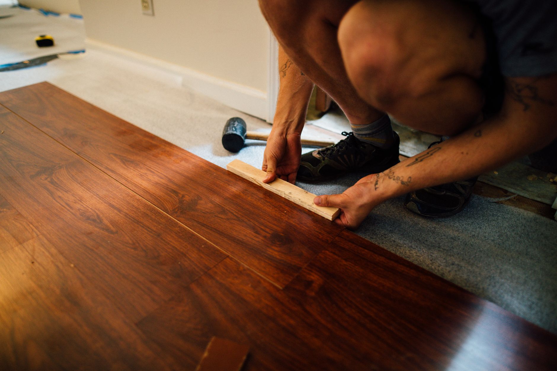 Handwerker verlegt Laminatdielen in einem Raum